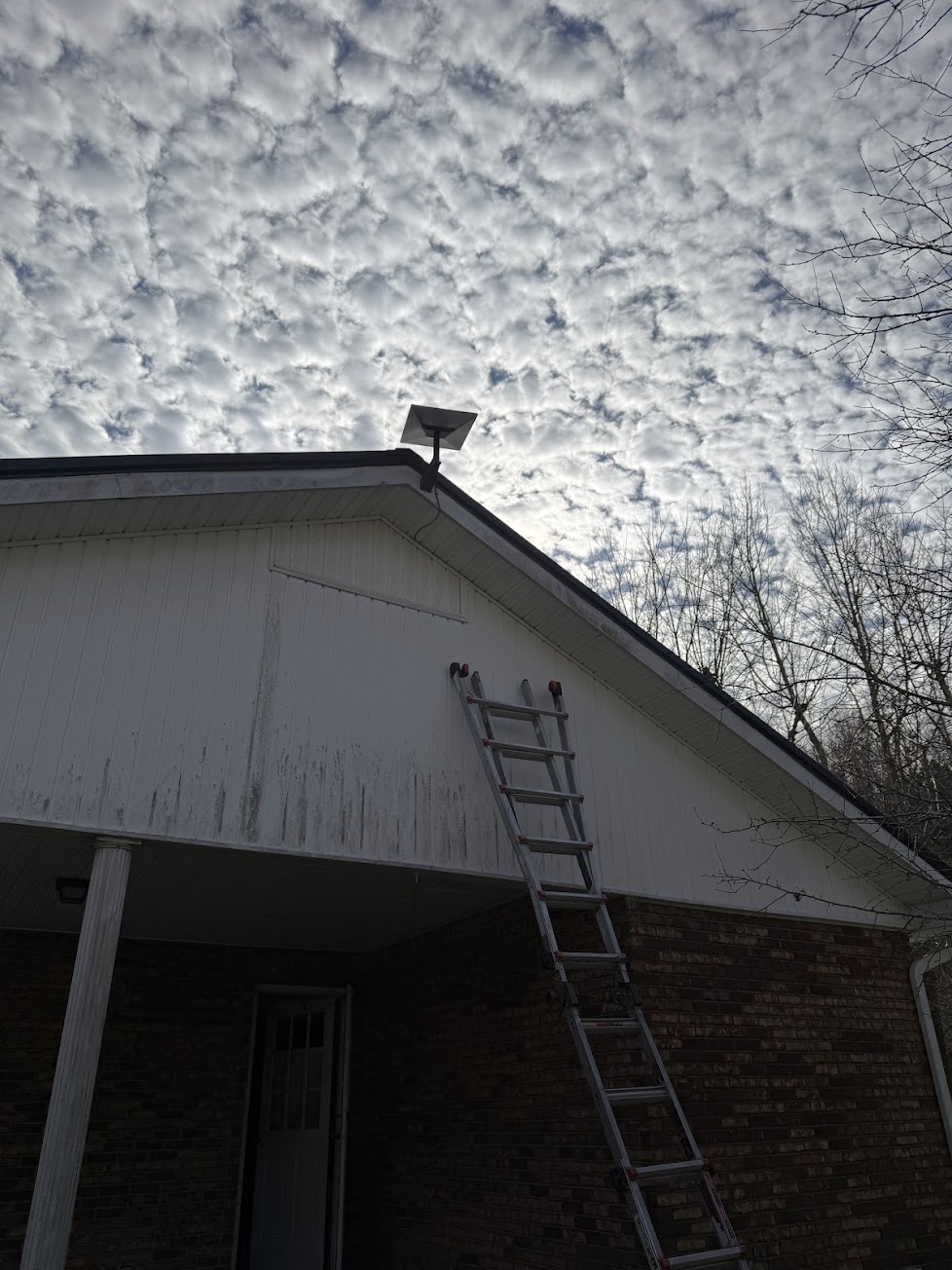 Starlink dish mounted above the gable of a two-story home