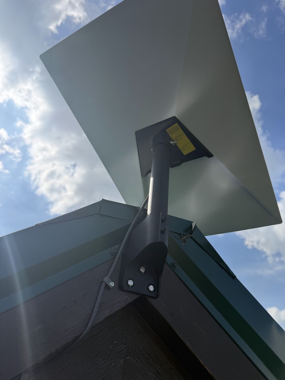 Close-up of Starlink dish hardware secured at a roof peak